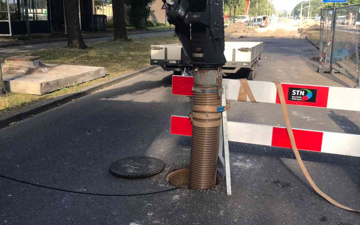 Zand wegzuigen uit duiker in Emmen