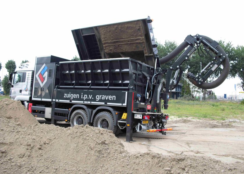 Vrachtauto kantelt en maakt zandbak